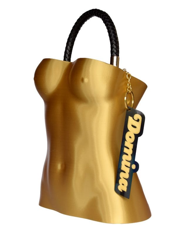 Bolso Domina diseñado por GalloBuey: una escultura de torso femenino en 3D dorado para complementar la colección de Juan Duyos en Madrid.