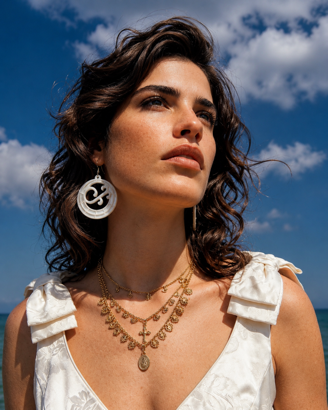 Mujer luciendo argollas canarias en color blanco mate, resaltando el diseño de media luna con un estilo minimalista y moderno.